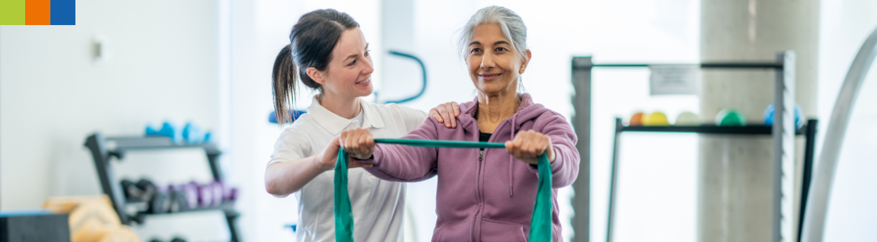 Eine Physiotherapeutin führt eine Behandlung an einer Patientin durch und erläutert eine Übung. Möchten Sie als Physiotherapeut*in in Deutschland arbeiten? Dann nehmen Sie am Anpassungslehrgang von IQ MUC teil.